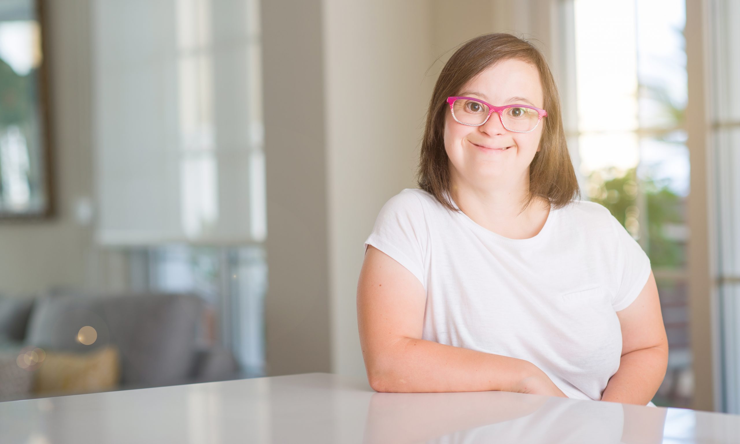 Smiling woman with down syndrome at home