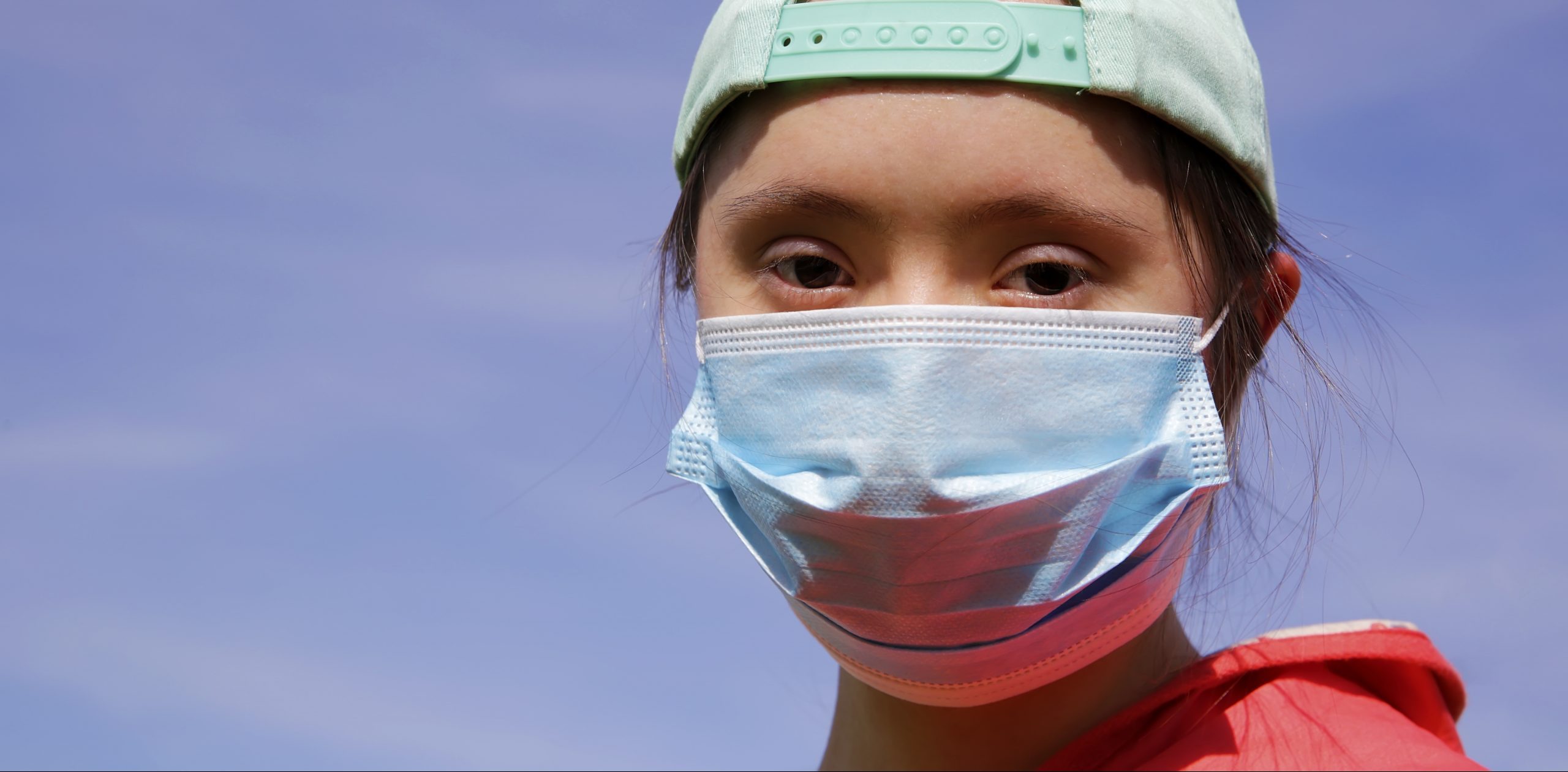 Girl with down syndrome wearing a mask